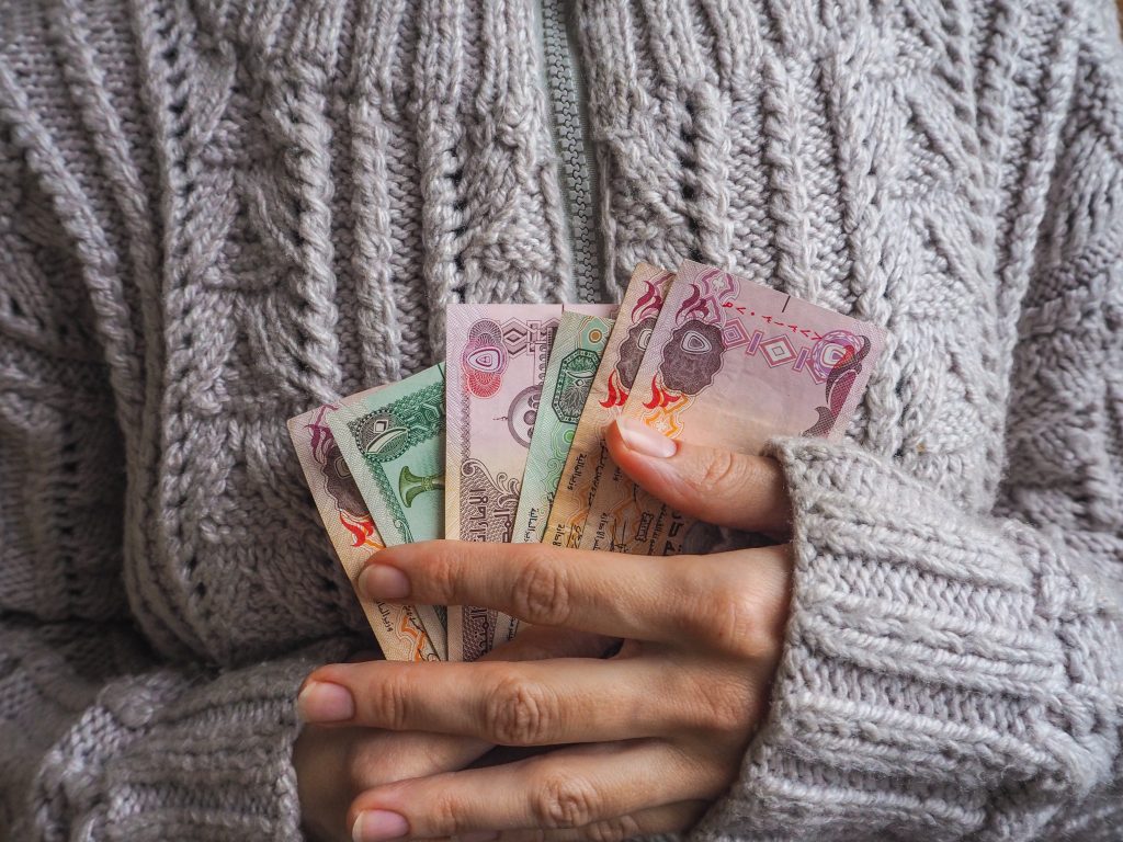 женские руки с дирхамами в руках